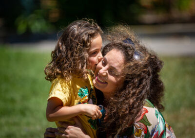 a boy kisses his mom on the cheak.