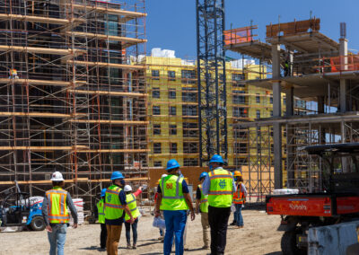 four people walking an apartment Highrise construction site