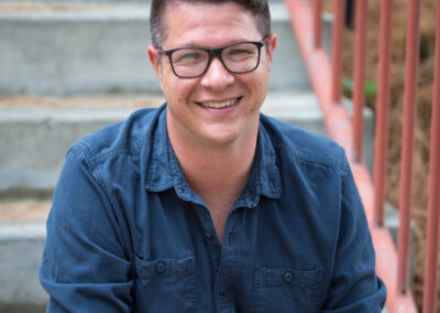 Headshot of a young man on concrete steps.