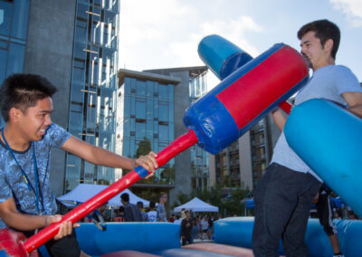 2 boys playfully battle with foam pugil sticks